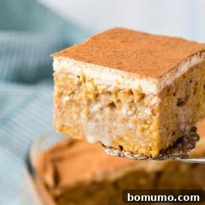 Pumpkin poke cake being scooped out of a baking dish.