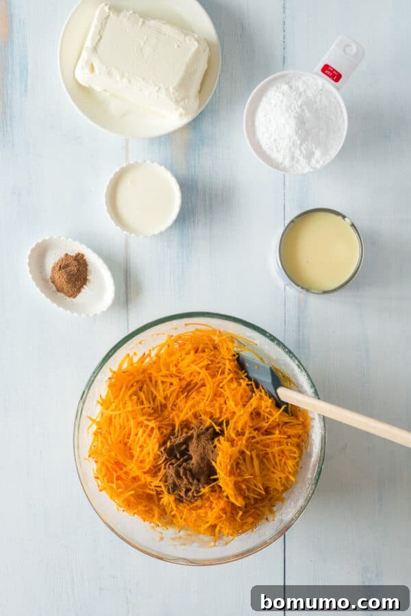 This pumpkin poke cake recipe is an easy fall dessert oozing with sweet cinnamon filling and smothered with tangy cream cheese frosting. Shredded pumpkin and pumpkin spice added to a bowl of pumpkin poke cake batter, surrounded by more ingredients on a countertop.