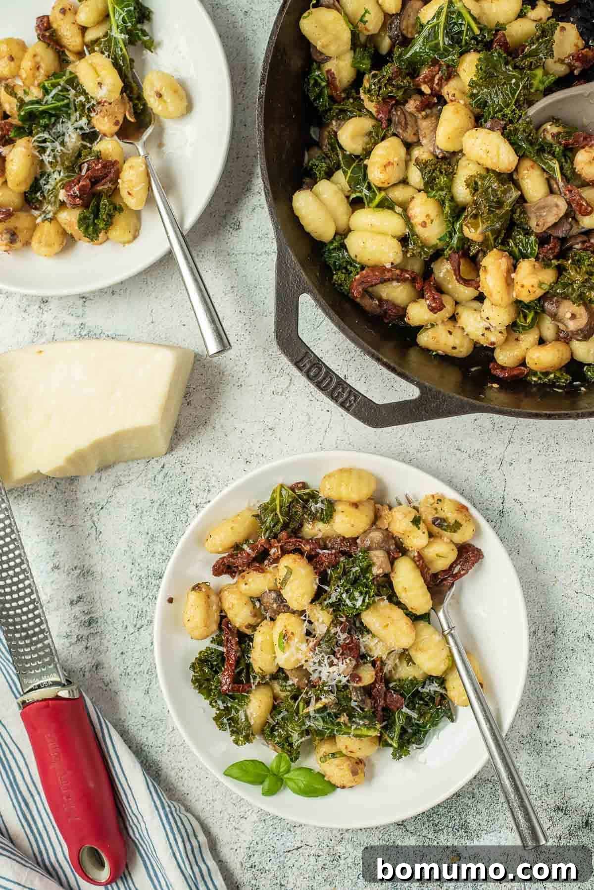 Overhead view of gnocchi with sun-dried tomatoes, kale, and mushrooms, showcasing the vibrant ingredients.