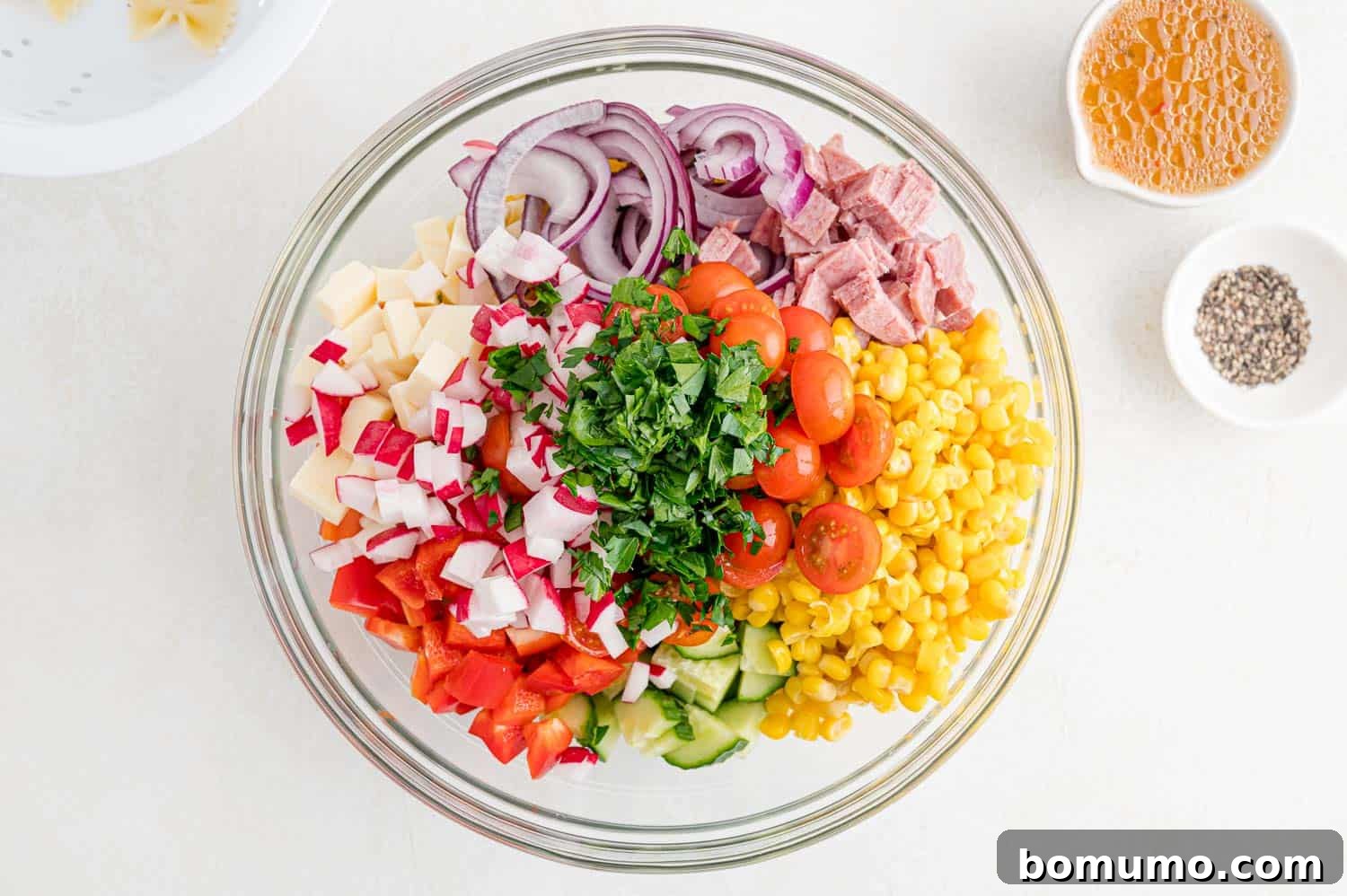 A colorful array of chopped fresh vegetables, including bell peppers, cucumbers, and tomatoes, gathered in a bowl.