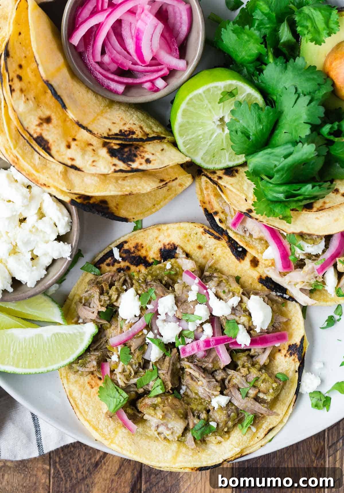 Overhead view of an open pork taco with assorted toppings.