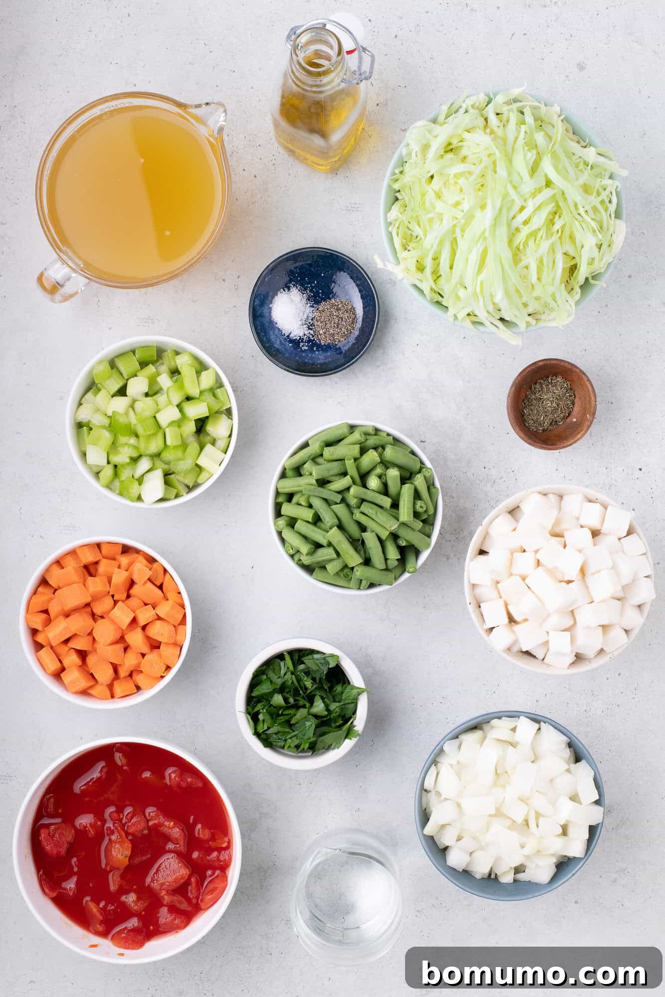 Fresh ingredients for homemade vegetable soup, including assorted chopped vegetables.