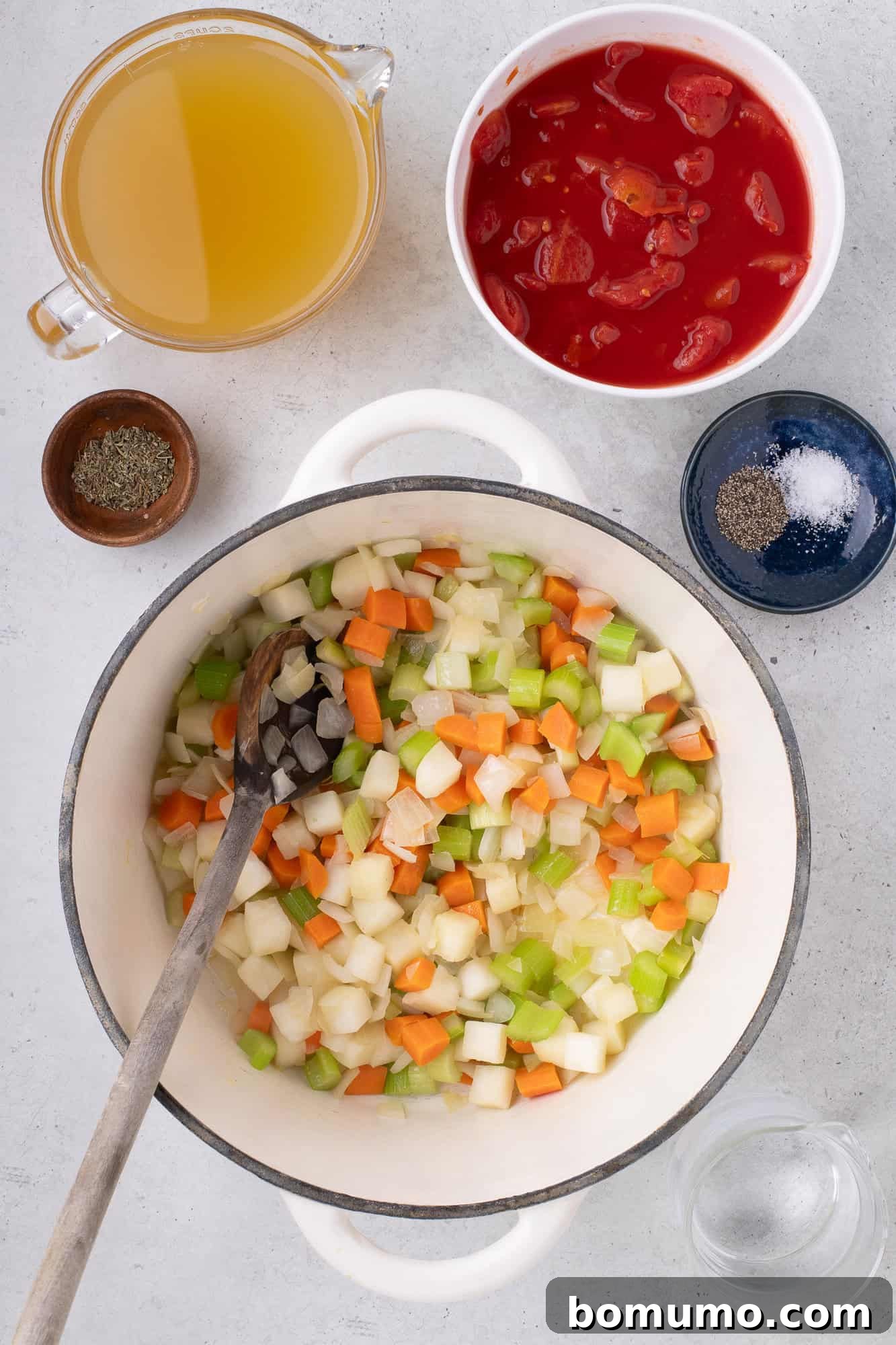 Sautéed vegetables in a large pot, softened and fragrant.