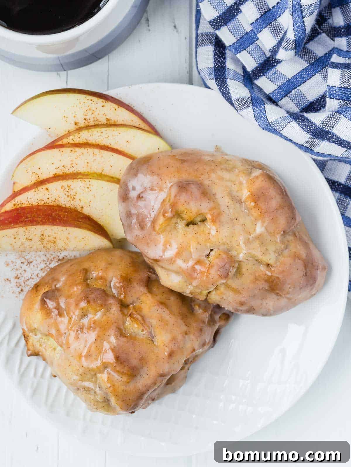 Delicious air fried apple fritters on a plate with sliced apples and coffee.