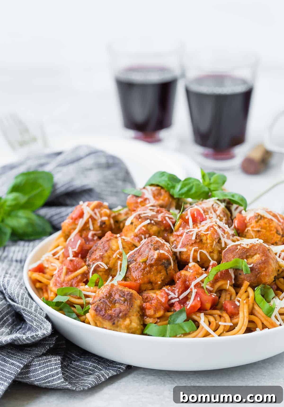 Spaghetti with meatballs, piled high in a white bowl.
