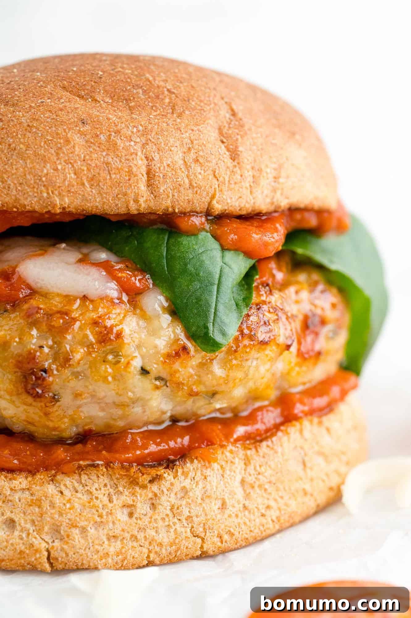 A mouth-watering pizza turkey burger served on a whole wheat bun, garnished with fresh basil, rich marinara sauce, and perfectly melted mozzarella cheese.