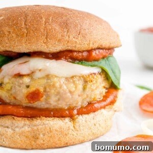 A vibrant pizza turkey burger presented on a whole wheat bun, garnished with fresh basil leaves, ready to be enjoyed.