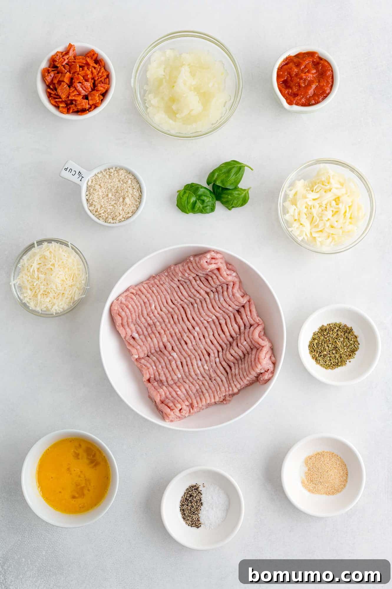 Individual bowls showcasing the fresh and high-quality ingredients for pizza turkey burgers, including lean ground turkey, ready for mixing.