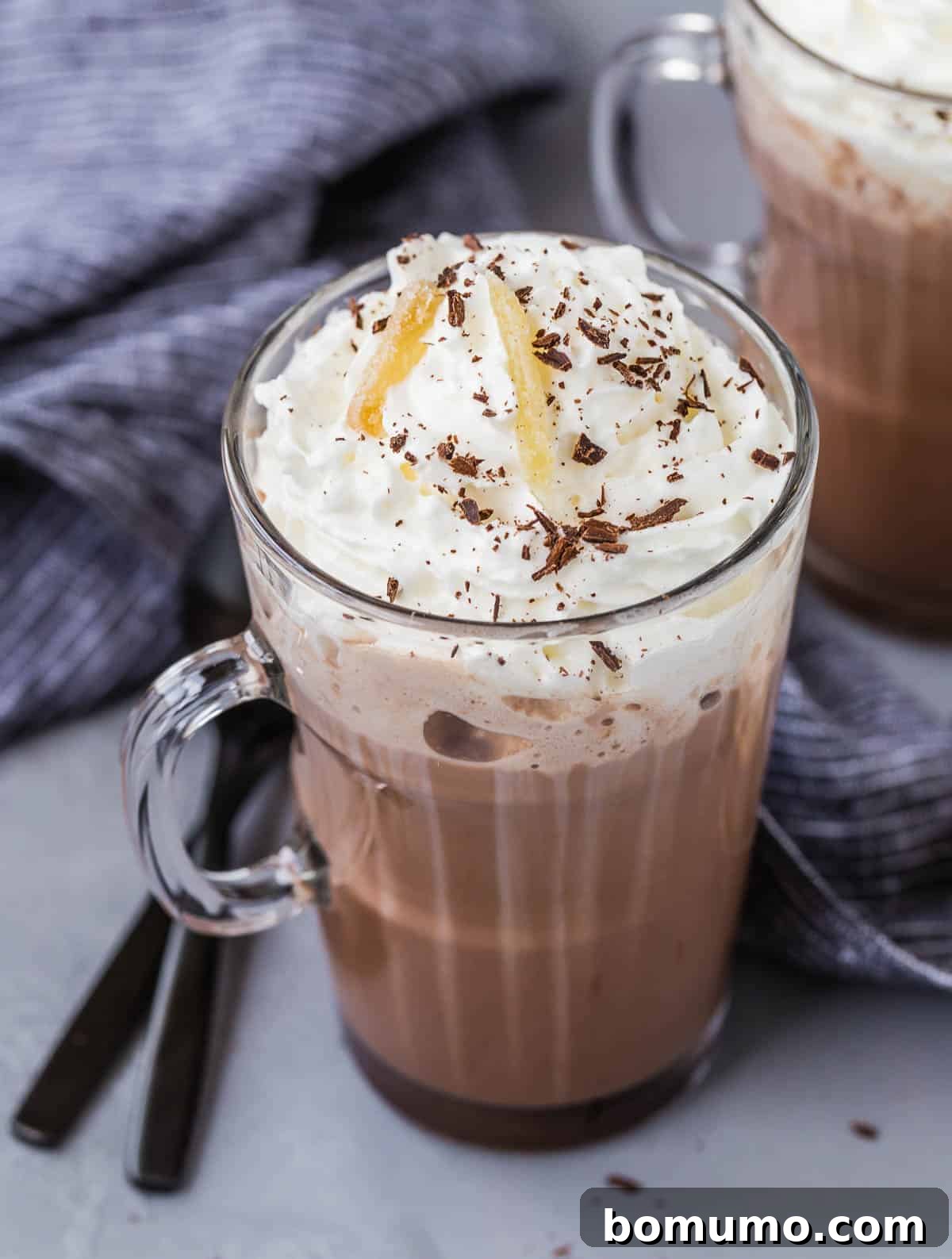A festive mug of ginger spiced hot chocolate topped with whipped cream and candied ginger, perfect for a cozy treat.