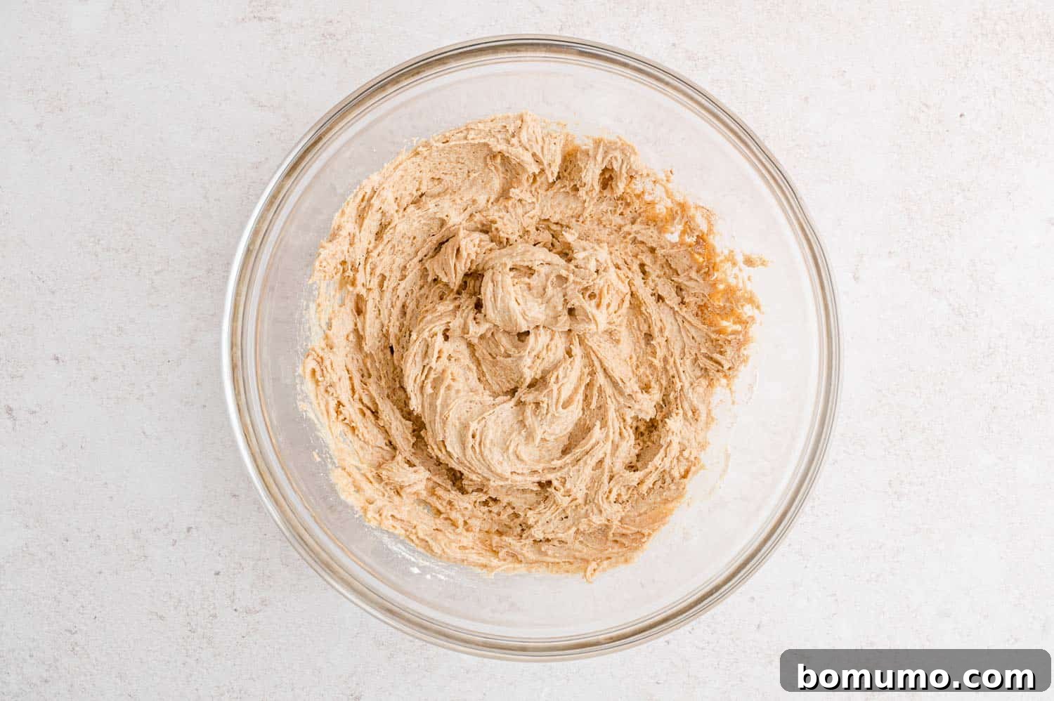 Apple spice cake batter in a glass bowl.