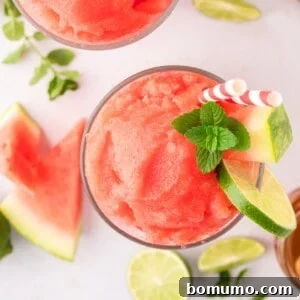 Overhead view of watermelon slushie garnished with lime and mint.