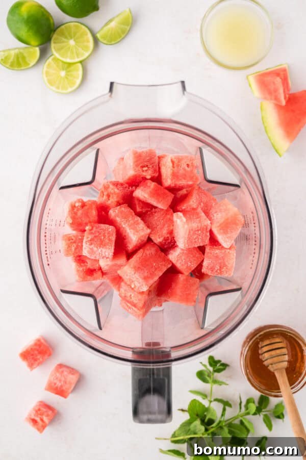 Close-up view of frozen watermelon cubes inside a blender, ready to be transformed into a refreshing slushie.
