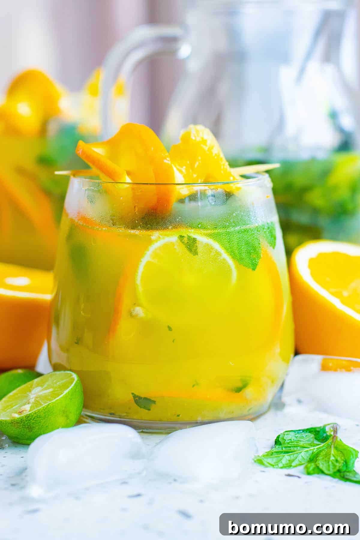 Sun-Kissed Mojito 7 A refreshing orange cocktail served in a tall glass, elegantly garnished with fresh mint leaves, orange slices, and a hint of lime, inviting a delightful sip.