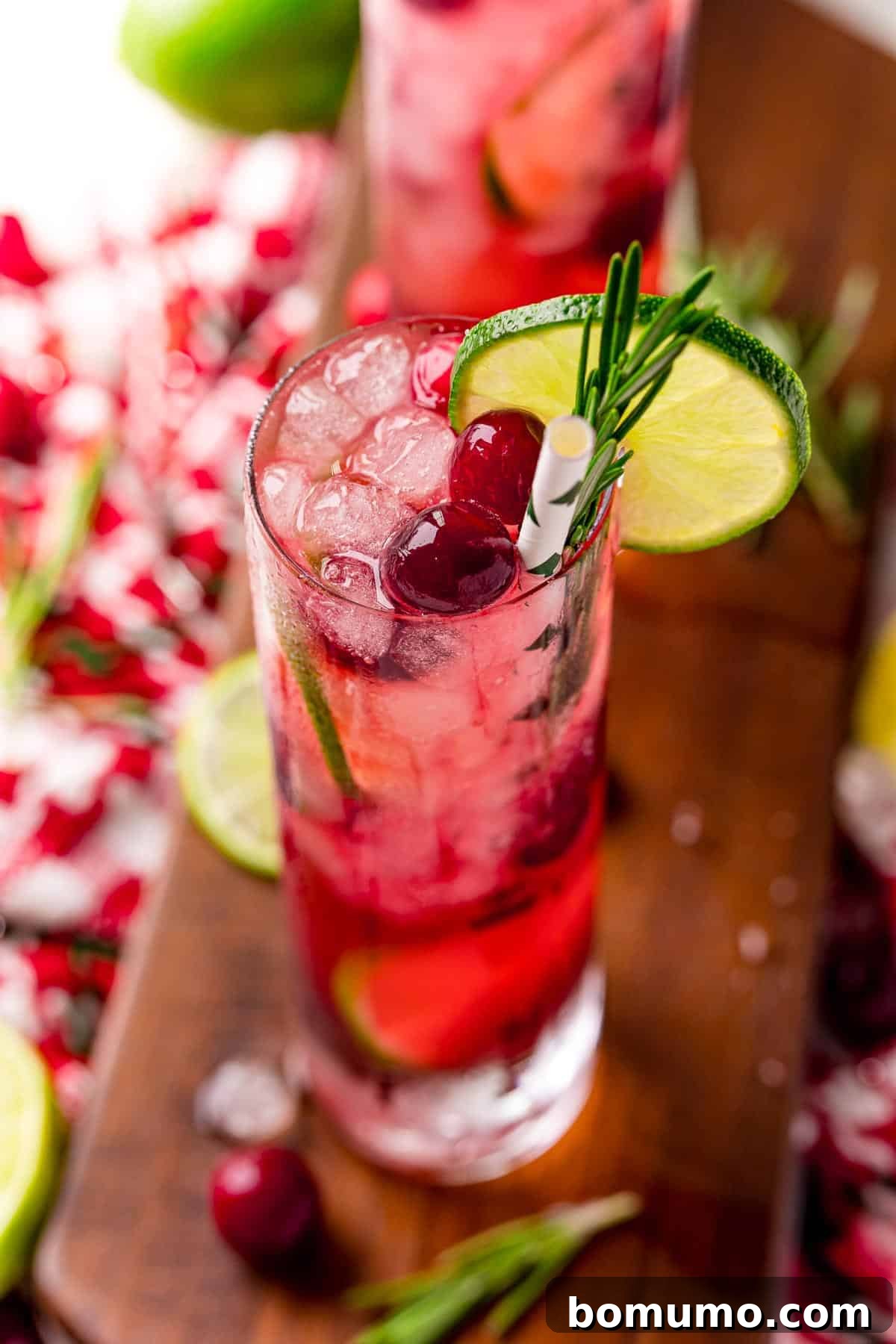 A bright red drink with cranberries and lime.