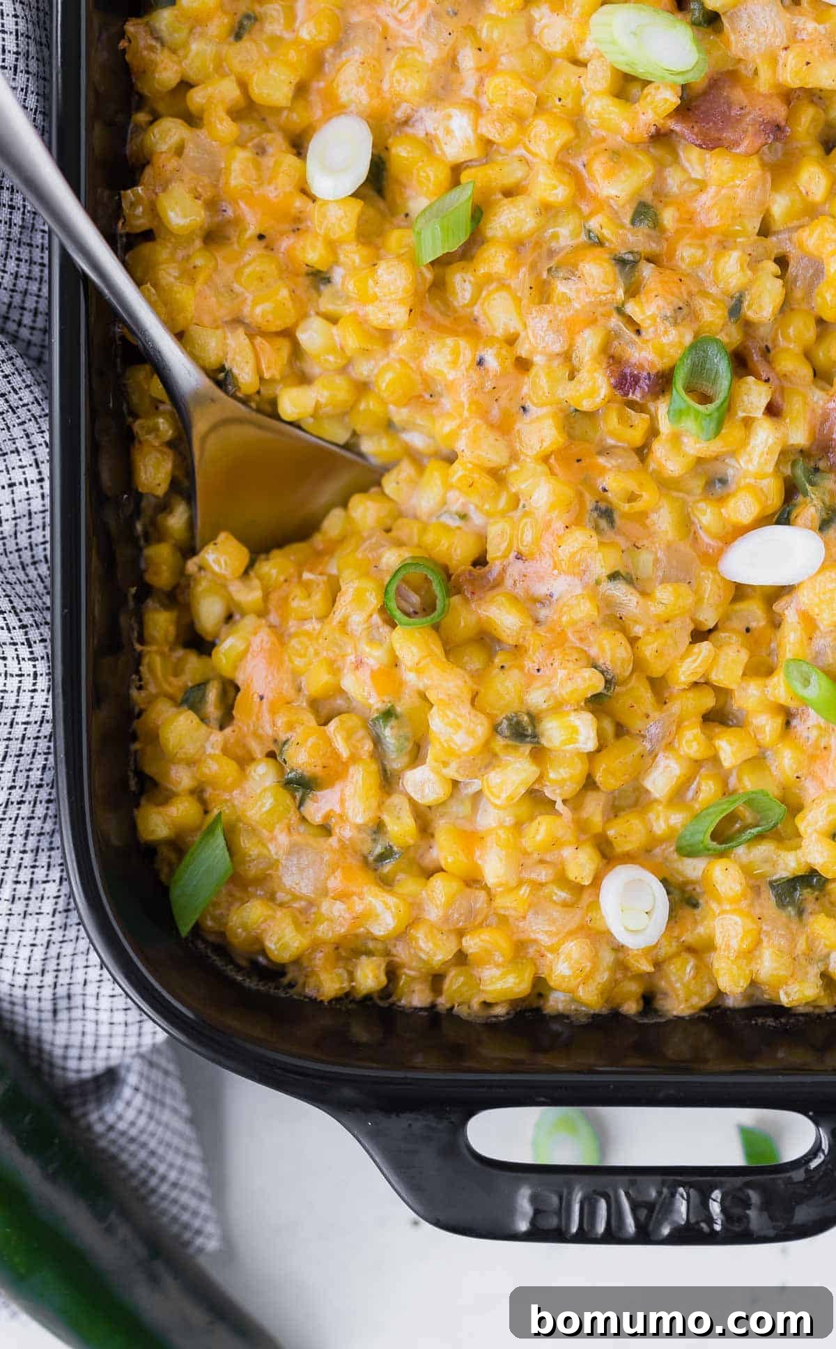 Overhead view of casserole made mainly of corn, sprinkled with sliced green onions.