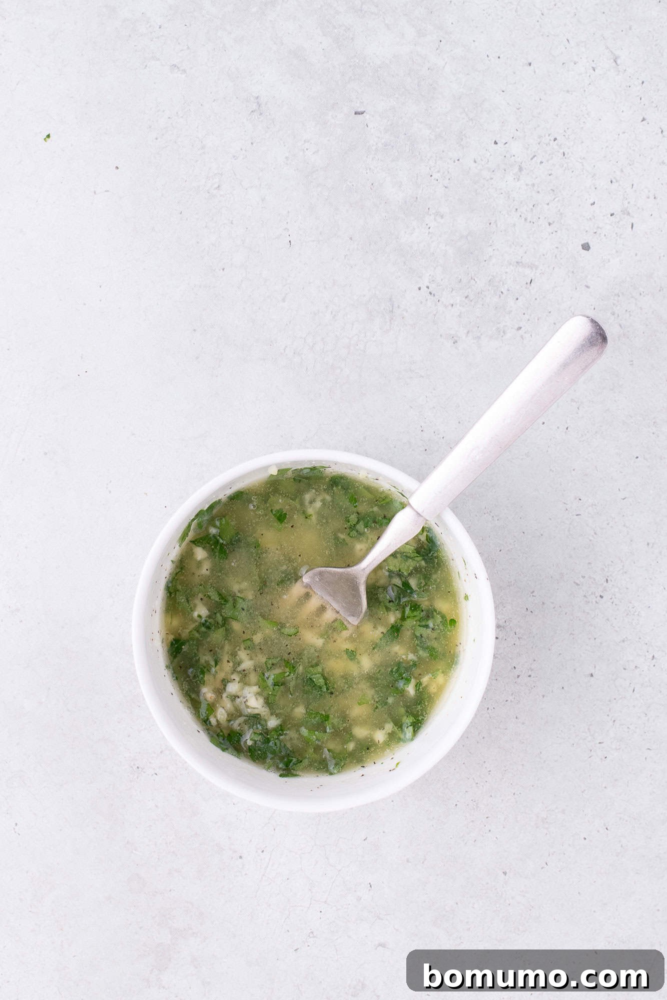 Garlic butter, mixed together in a small glass bowl.