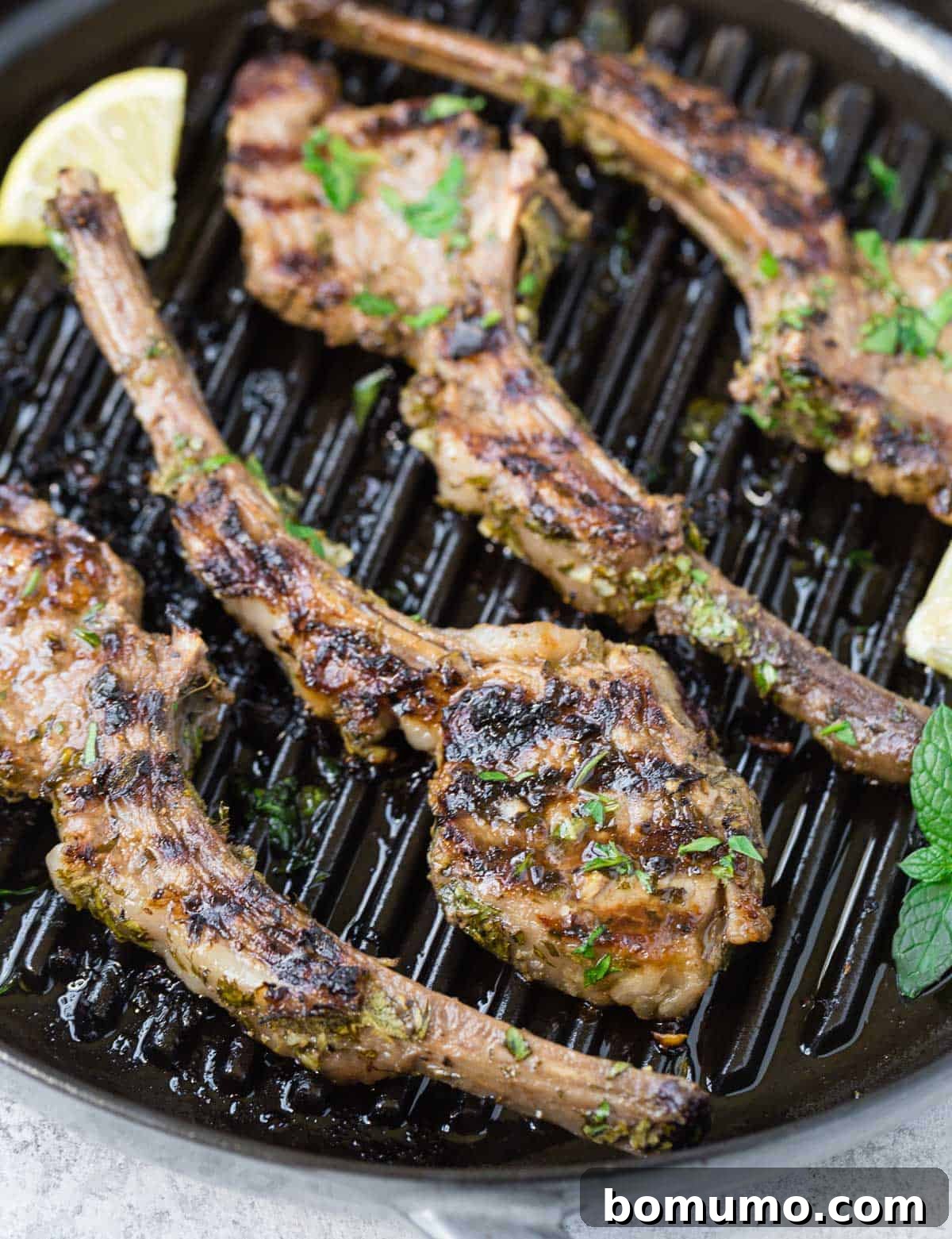 Aromatic Garlic Herb Lamb Chops 3 Perfectly seared lamb chops resting on a hot grill pan, showcasing their beautiful char.