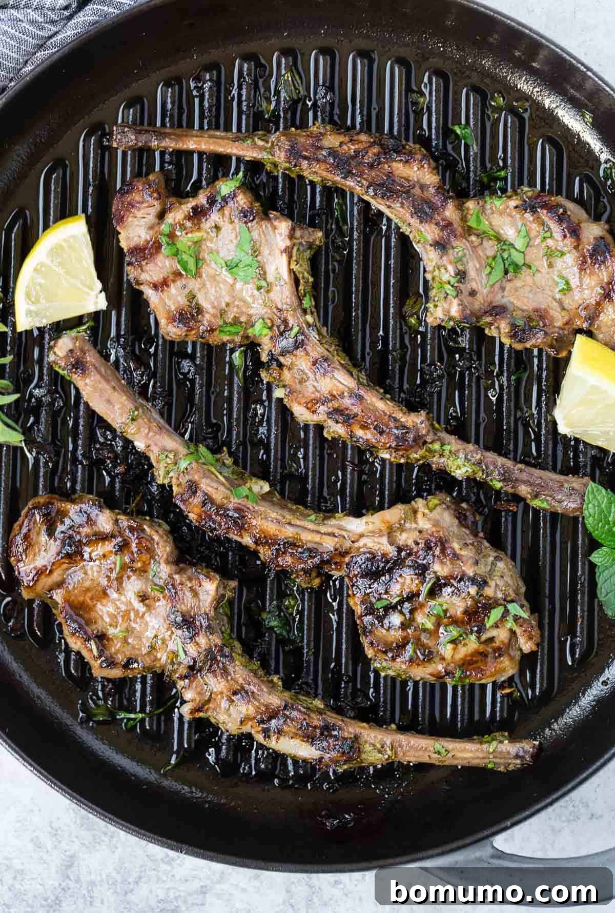 Aromatic Garlic Herb Lamb Chops 5 A round grill pan filled with succulent cooked lamb chops, garnished generously with fresh herbs.
