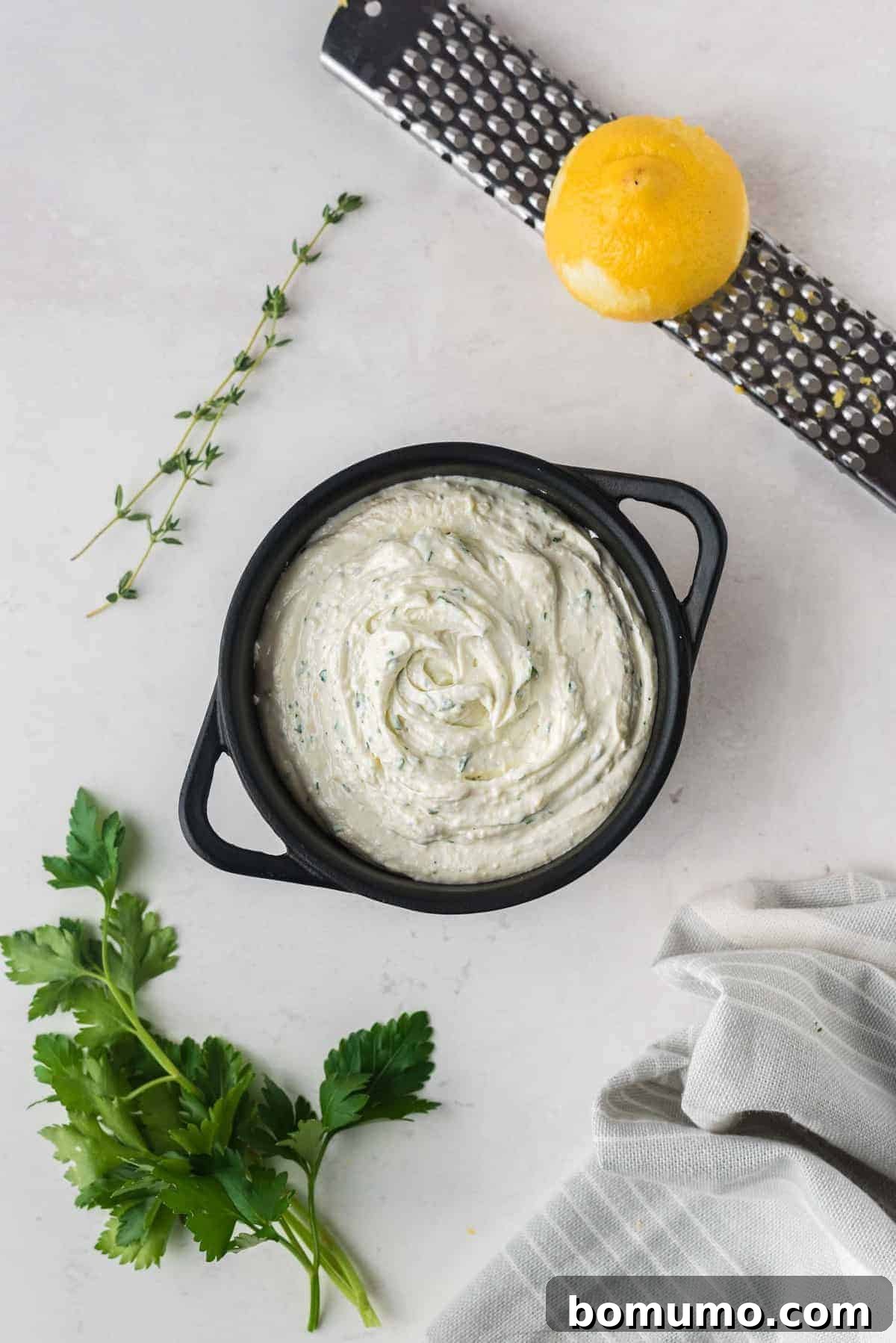 Unbaked goat cheese spread in a black baking dish.