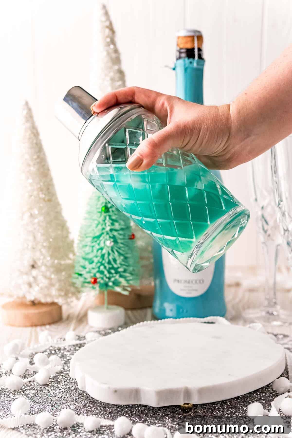 Blue drink in a cocktail shaker, illustrating the mixing process for the Jack Frost Mimosa.