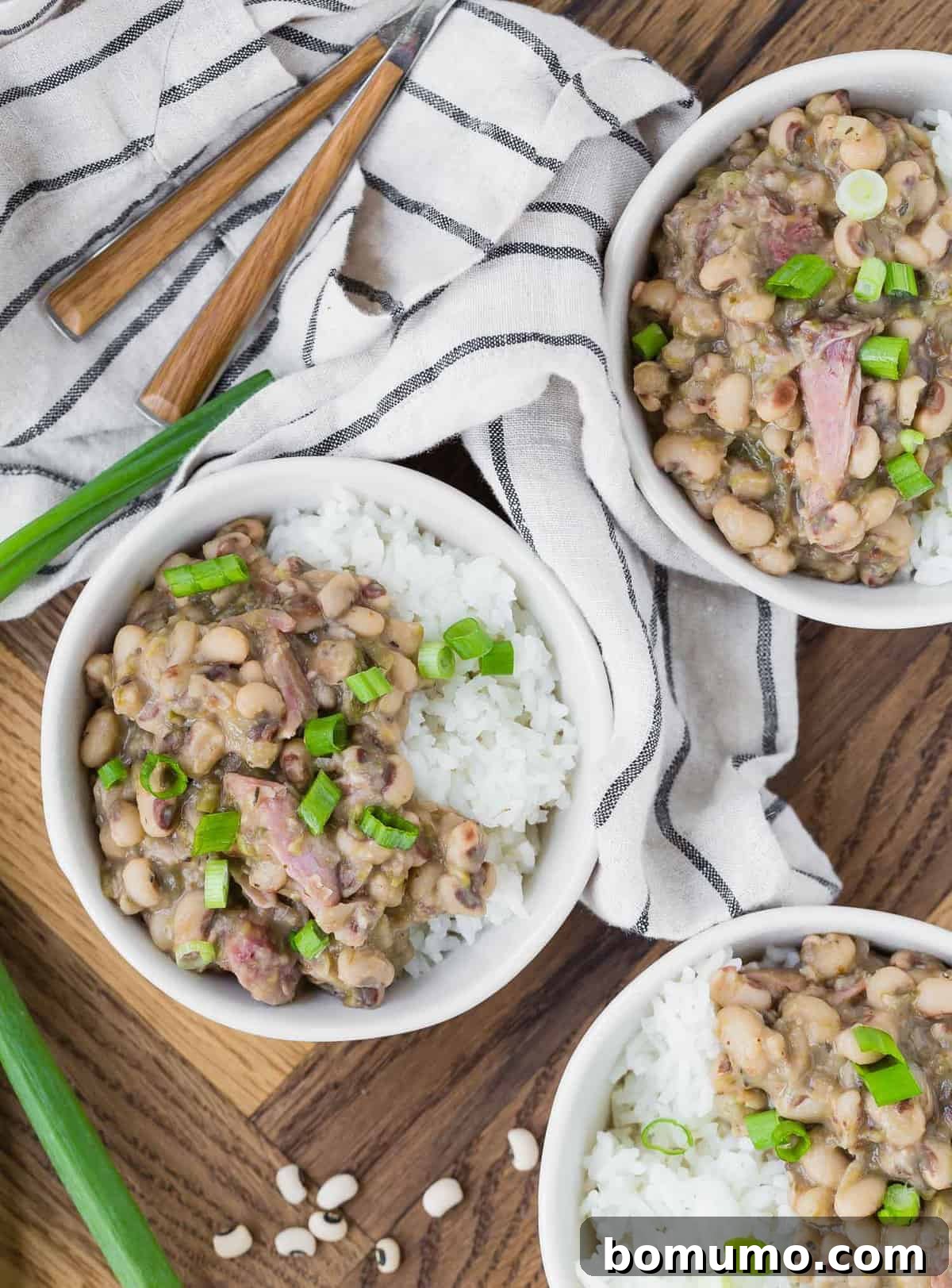 three bowls of hoppin' john on a wooden background