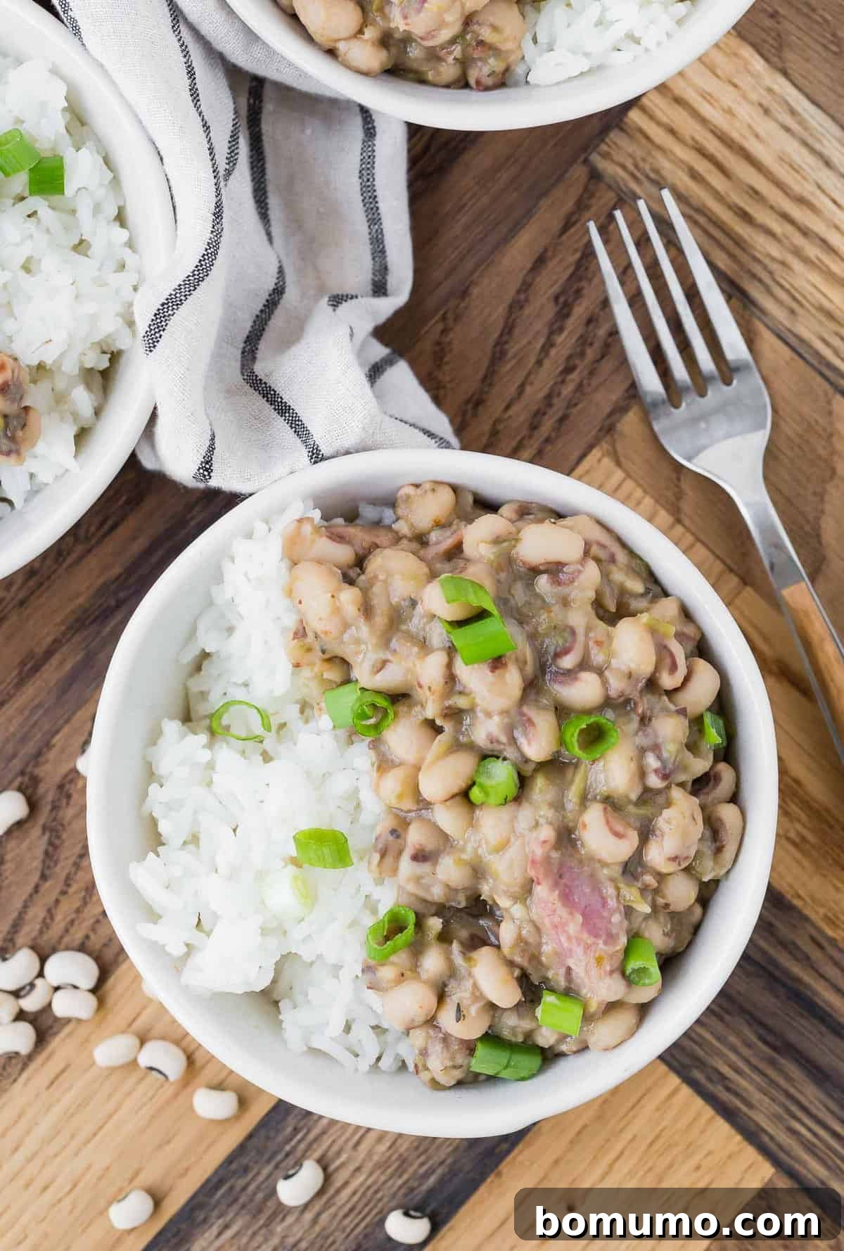 Overhead view of cooked black eyed peas served over white rice.