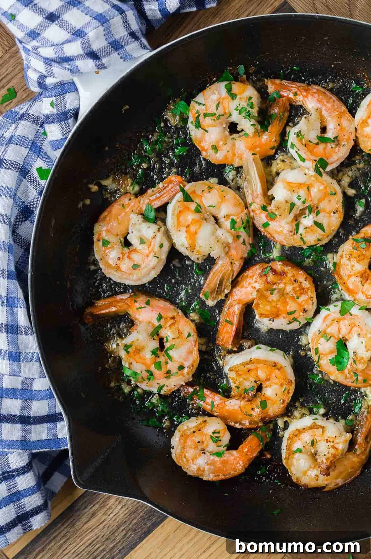 Effortless Lemon Pepper Shrimp 3 Sizzling lemon pepper shrimp cooking in a black cast iron skillet, emitting an enticing aroma.