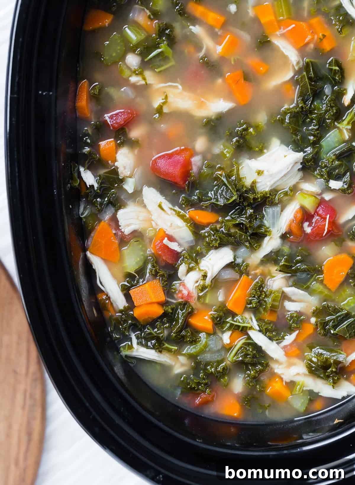 Close up of soup in a black slow cooker.