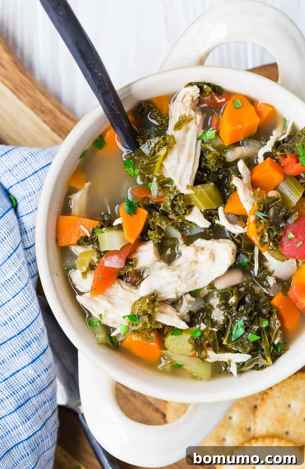 A bowl of soup with a black-handled spoon in it.