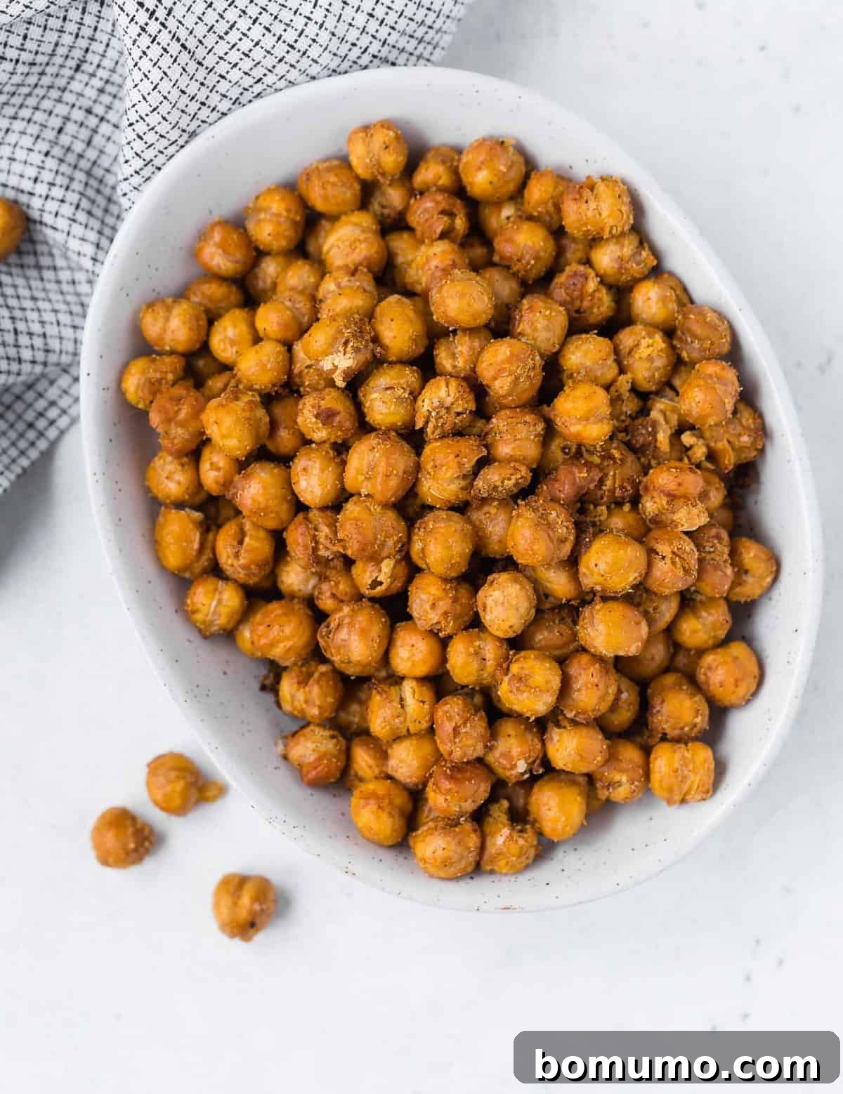 Overhead view of a white bowl filled to the brim with golden-brown fried chickpeas.