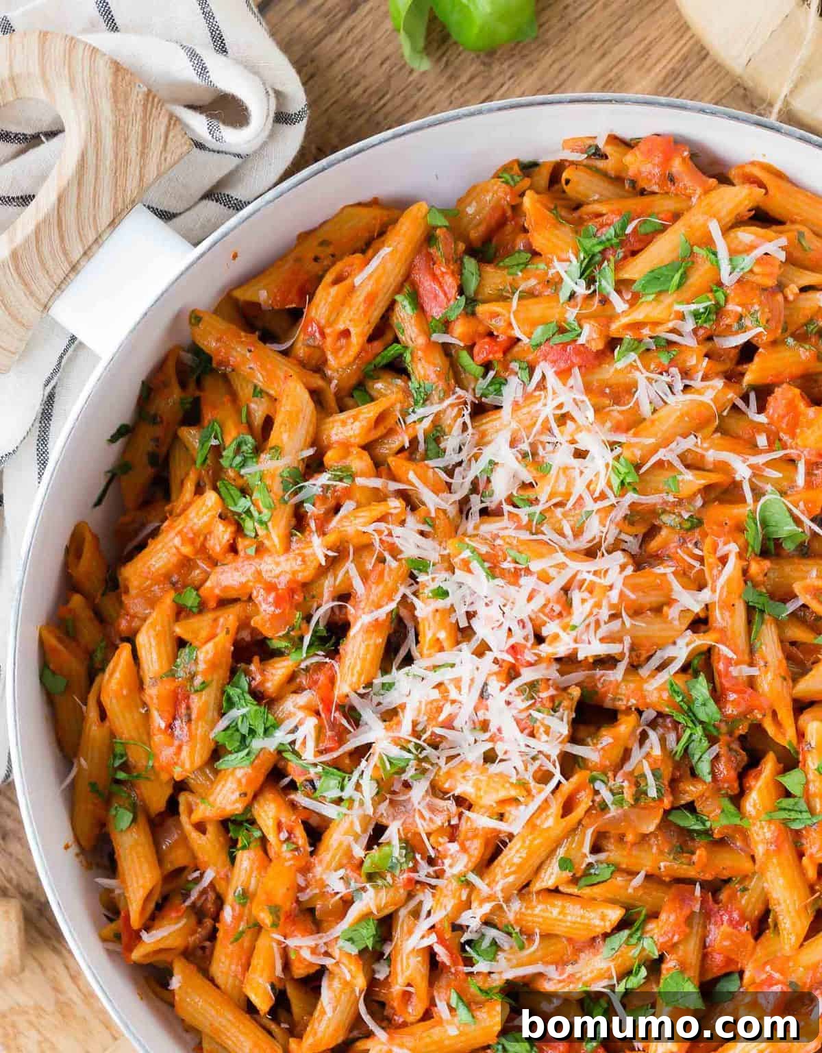 Overhead view of pasta in a tomato based sauce, topped with cheese.