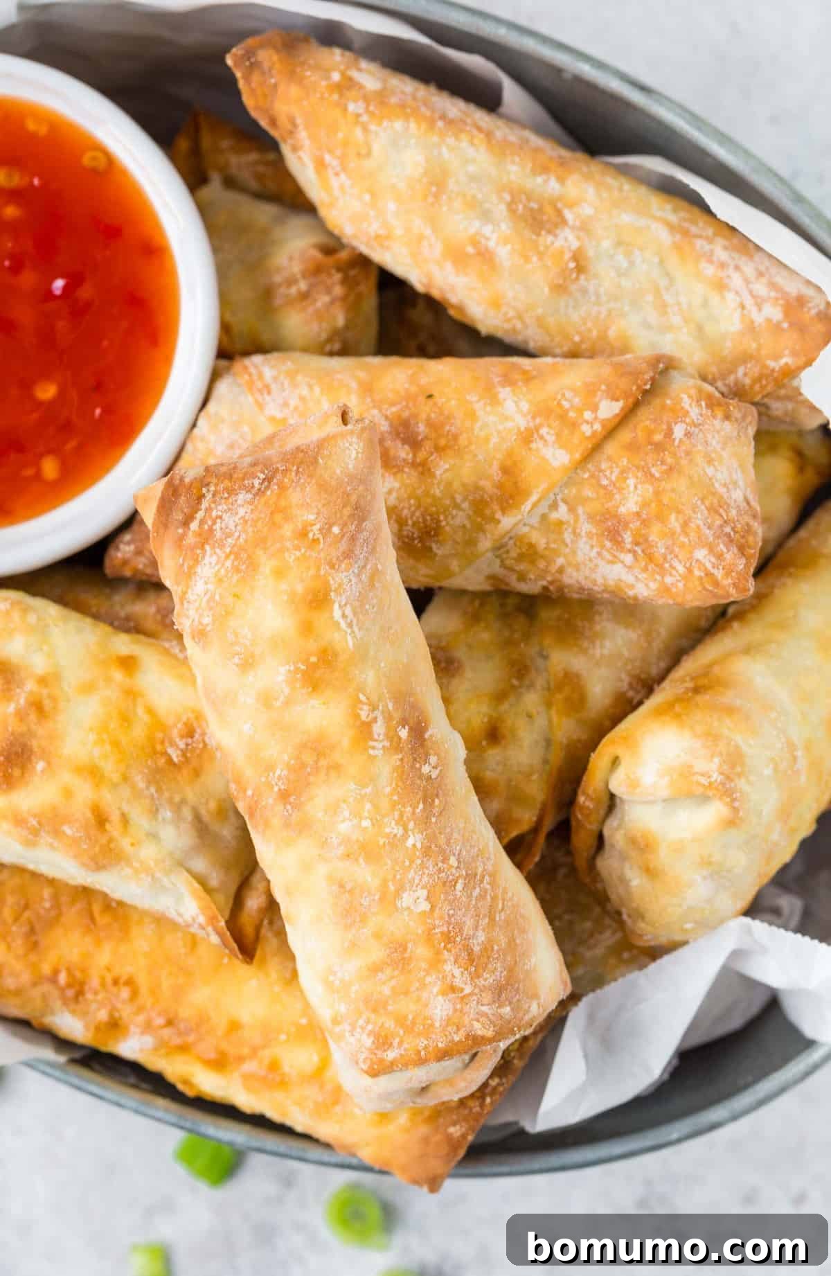 A close-up overhead view of several perfectly golden brown air fried egg rolls, ready to be served.