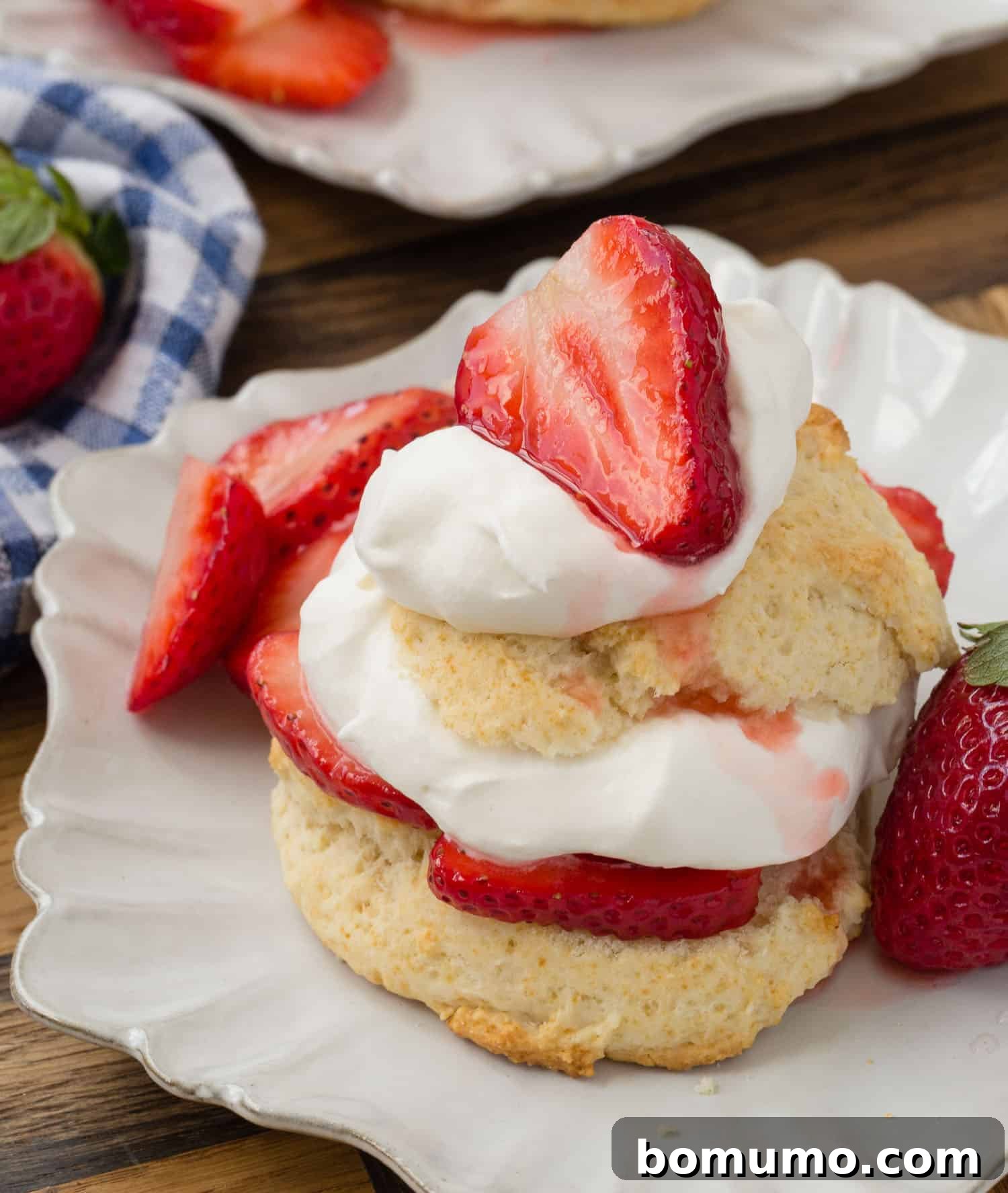 A shortcake split in half and filled with whipped cream and strawberries.