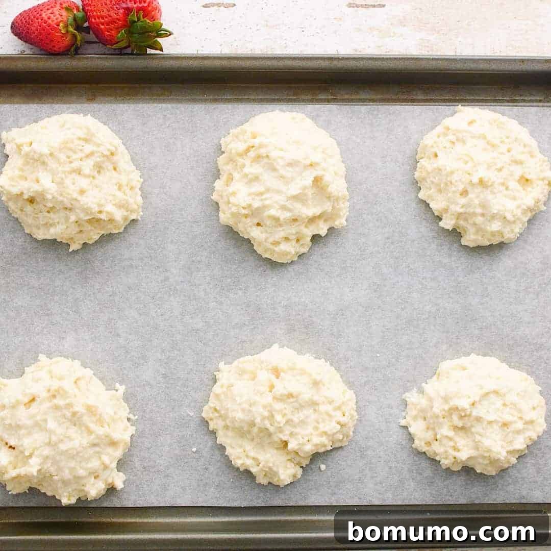 Unbaked shortcakes on a tray.