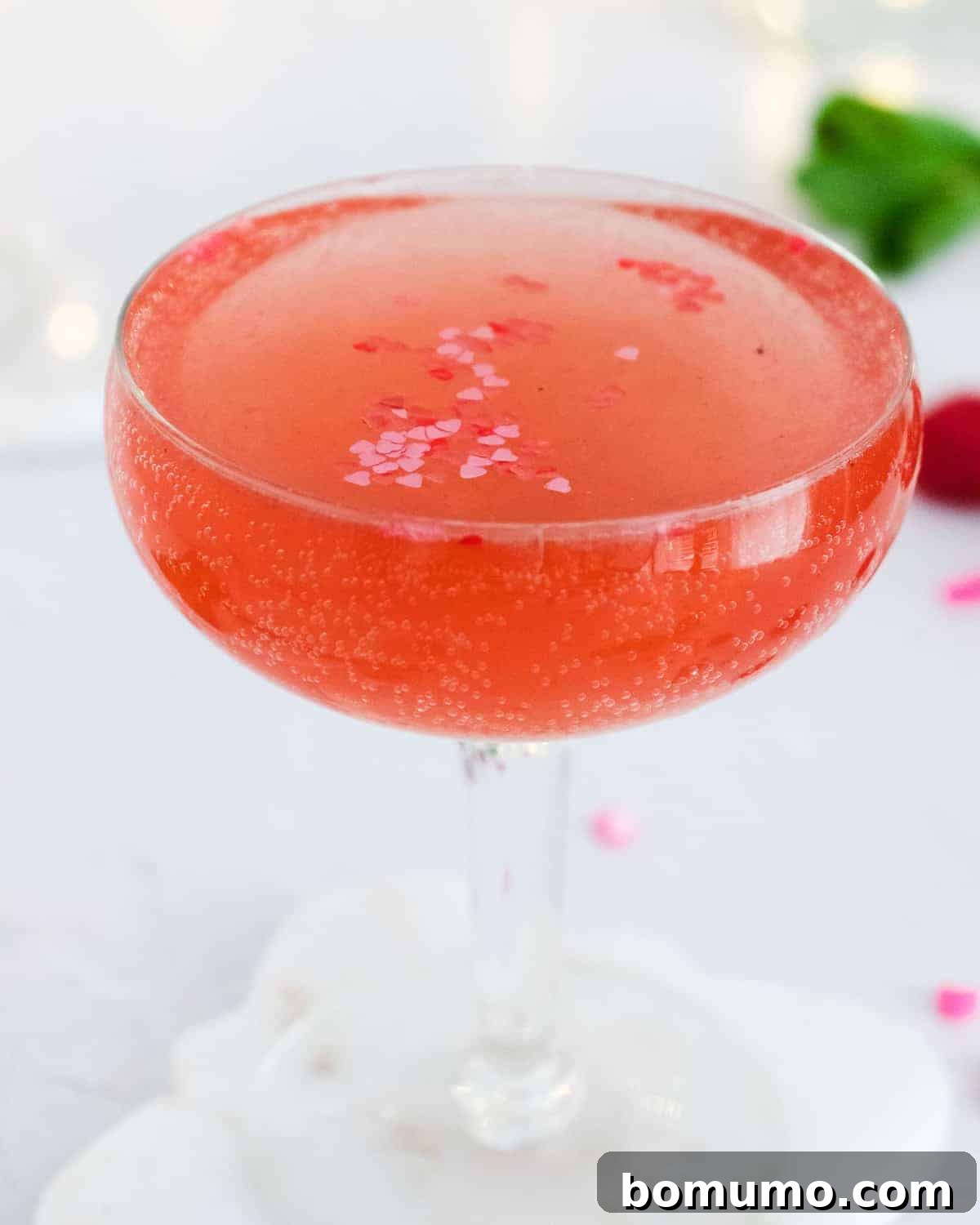 Close up of a sparkling pink drink with delicate heart sprinkles, adding a festive touch.