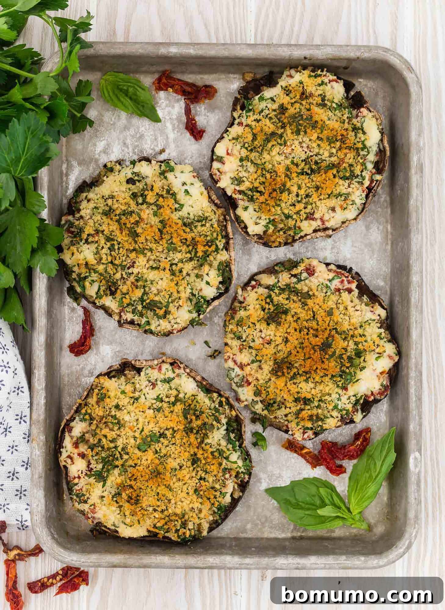 Stuffed Portobello Delight 12 Overhead view of 4 portobello mushrooms on a baking sheet, filled with stuffing and baked.