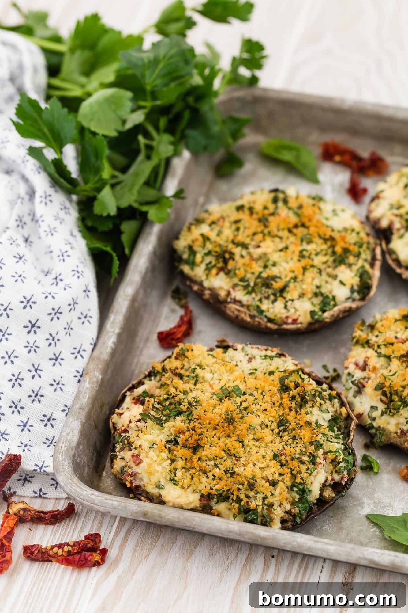 Stuffed Portobello Delight 10 Stuffed mushrooms on a metal baking sheet, with parsley in background.
