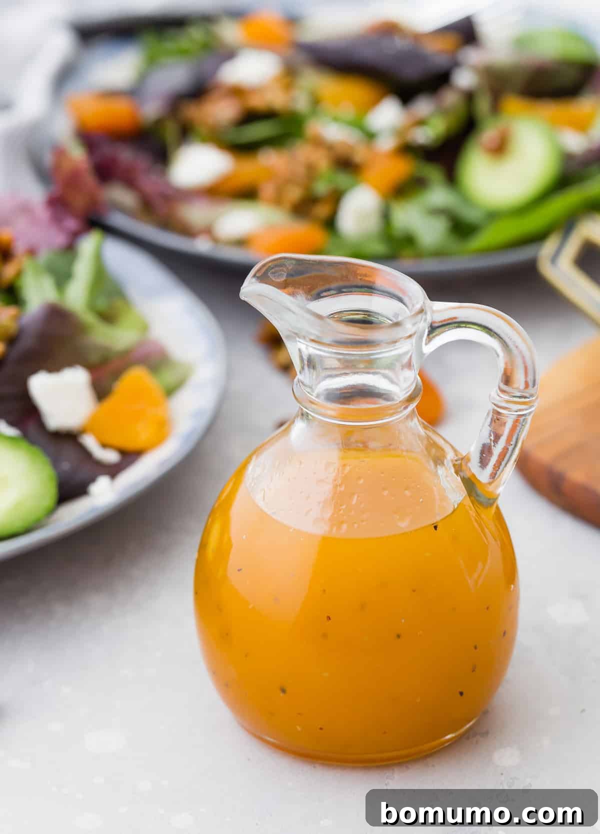 Apricot salad dressing in a small glass pitcher.