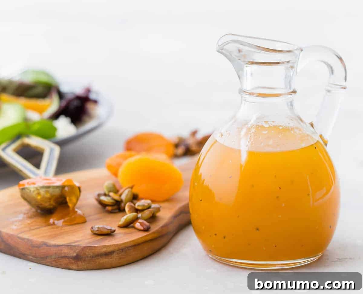 Dressing in a small glass jar next to a small cutting board with apricots.