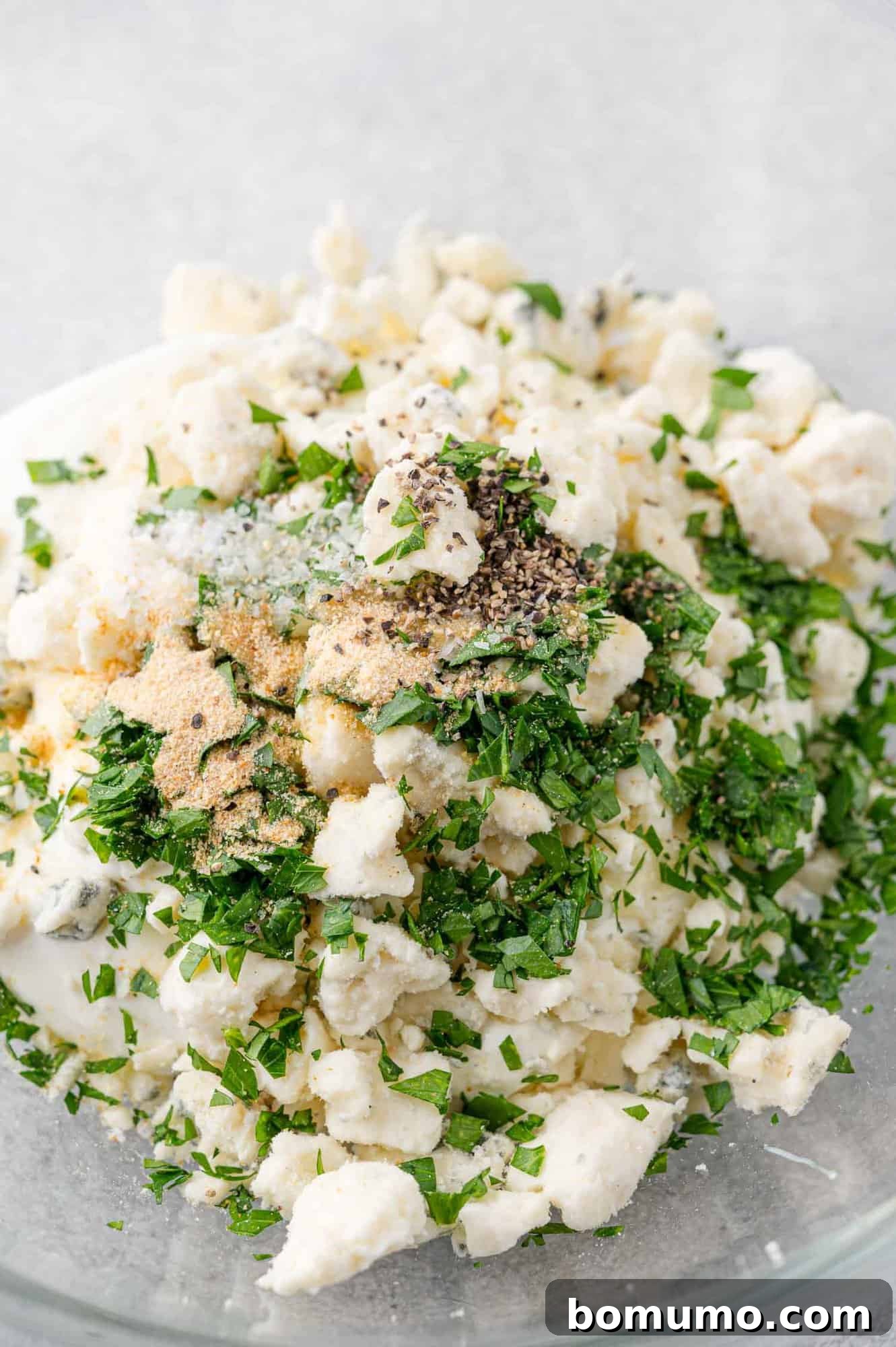 The dressing ingredients assembled in a clear glass bowl, ready to be mixed together.