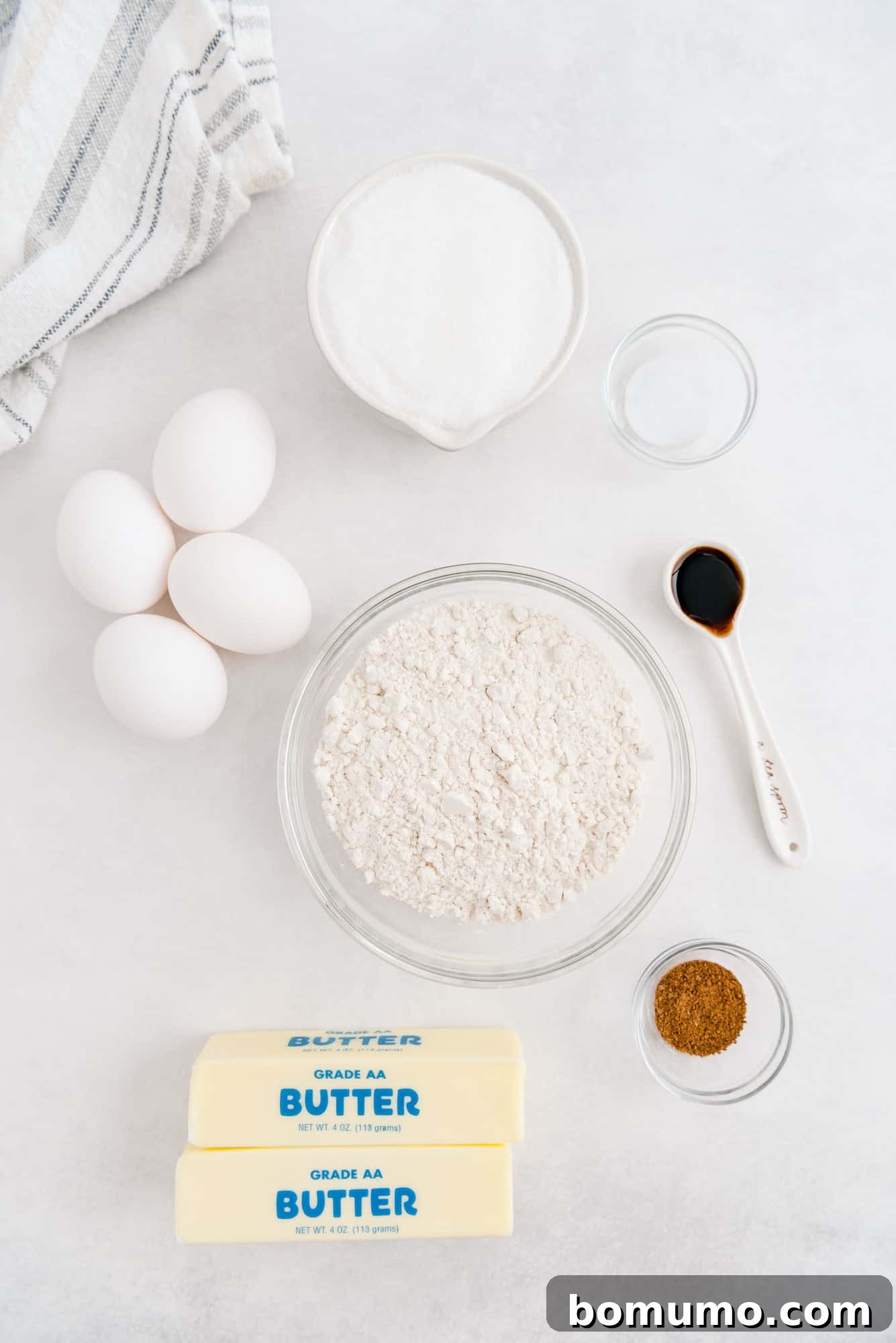 Timeless Pound Cake Perfection 4 Overhead view of fresh ingredients neatly arranged: softened butter, large eggs, all-purpose flour, granulated sugar, pure vanilla extract, and a pinch of nutmeg, ready for baking.