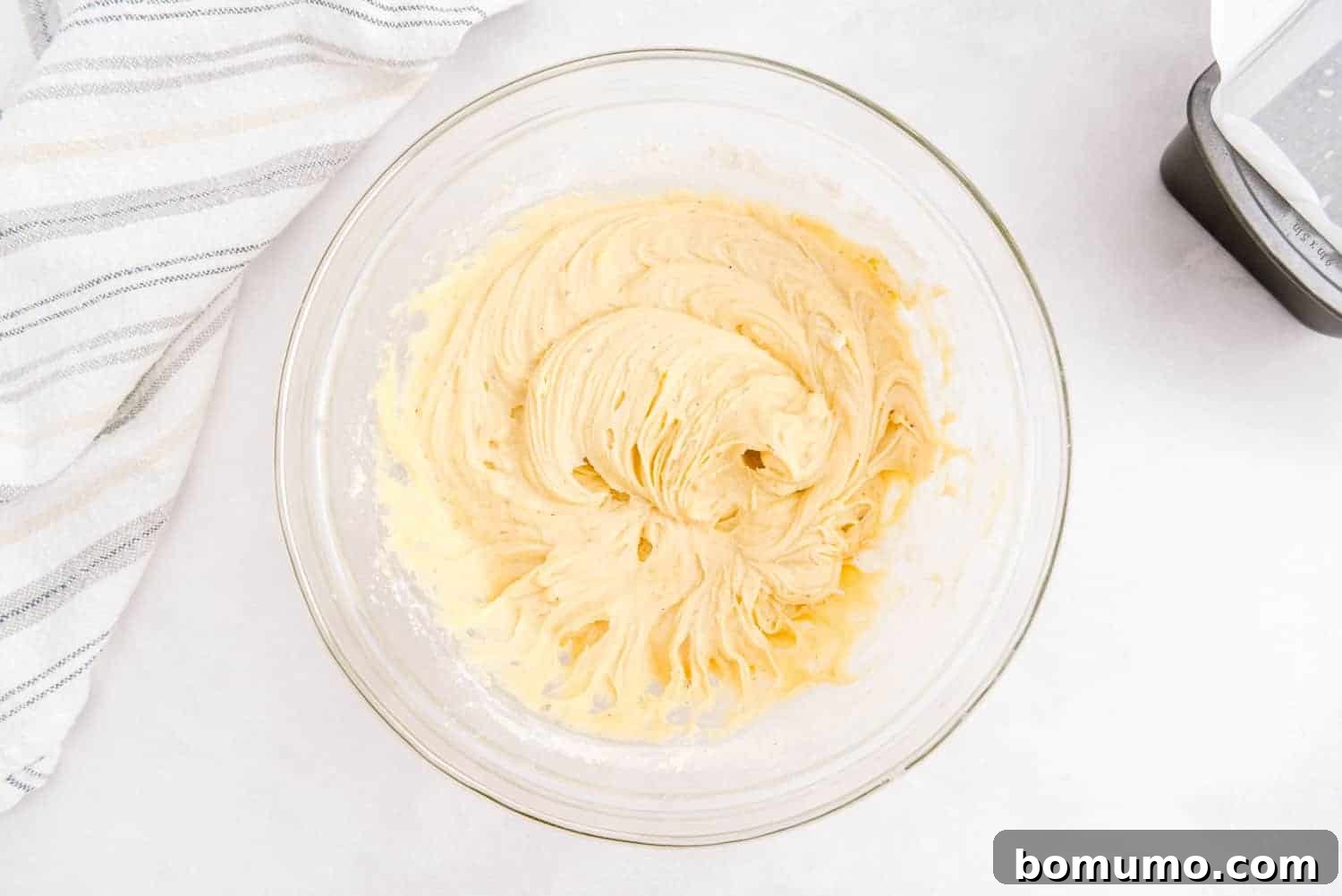 Timeless Pound Cake Perfection 8 Thick, rich pound cake batter rests in a clear glass mixing bowl, perfectly mixed and ready for the pan.