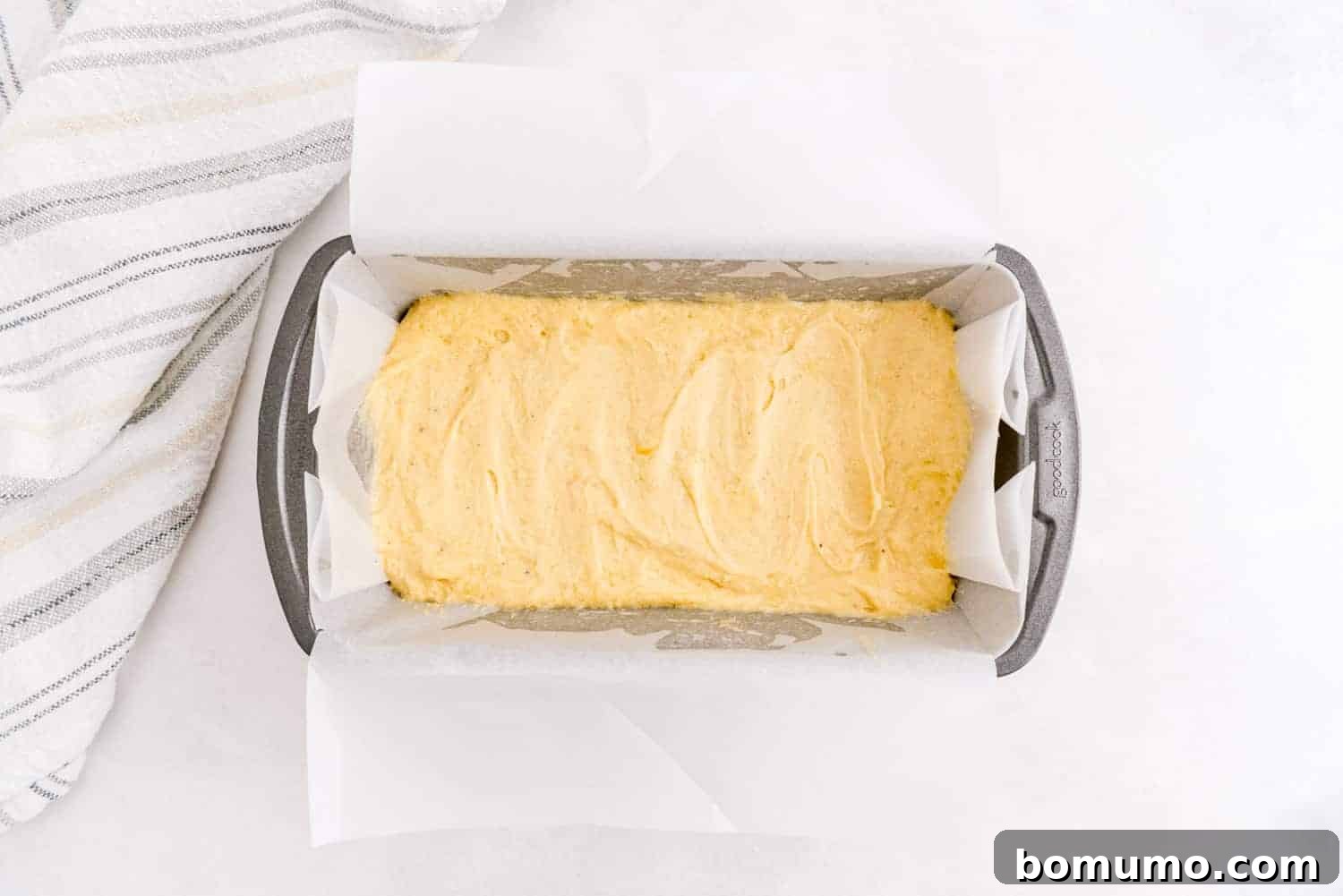 Timeless Pound Cake Perfection 9 The unbaked pound cake batter, smoothed into a parchment-lined loaf pan, poised for baking.