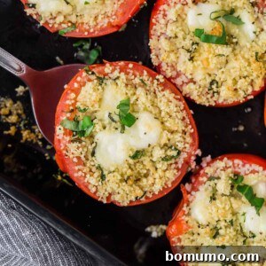 Overhead view of stuffed tomatoes in a black dish.