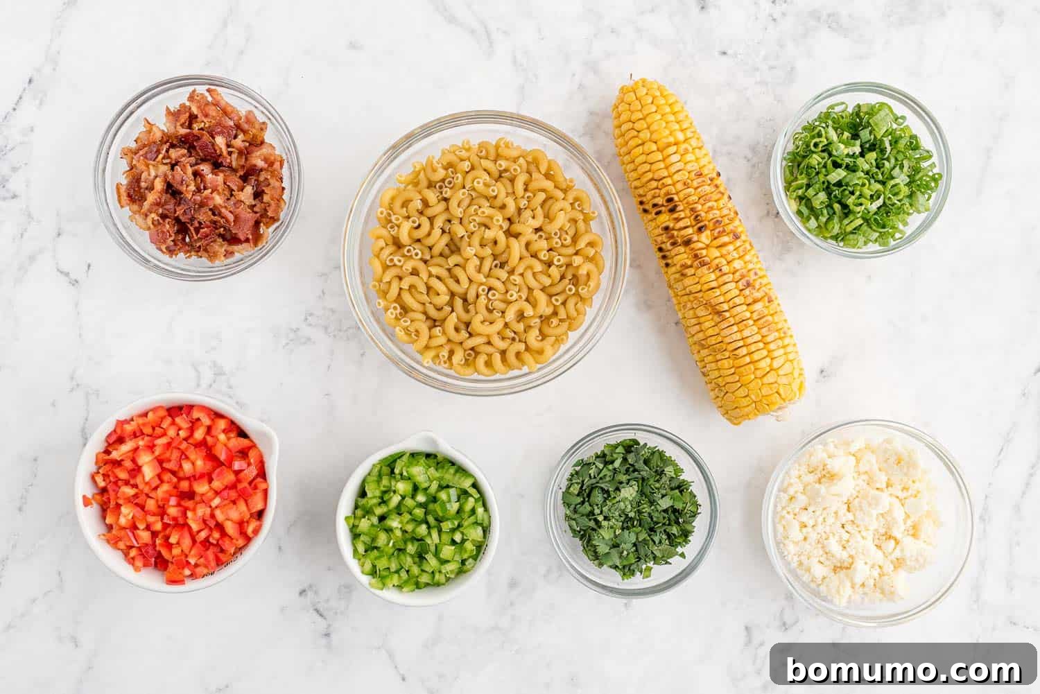 An inviting overhead shot showcasing all the fresh, colorful ingredients meticulously laid out for the Mexican street corn pasta salad, awaiting their transformation.