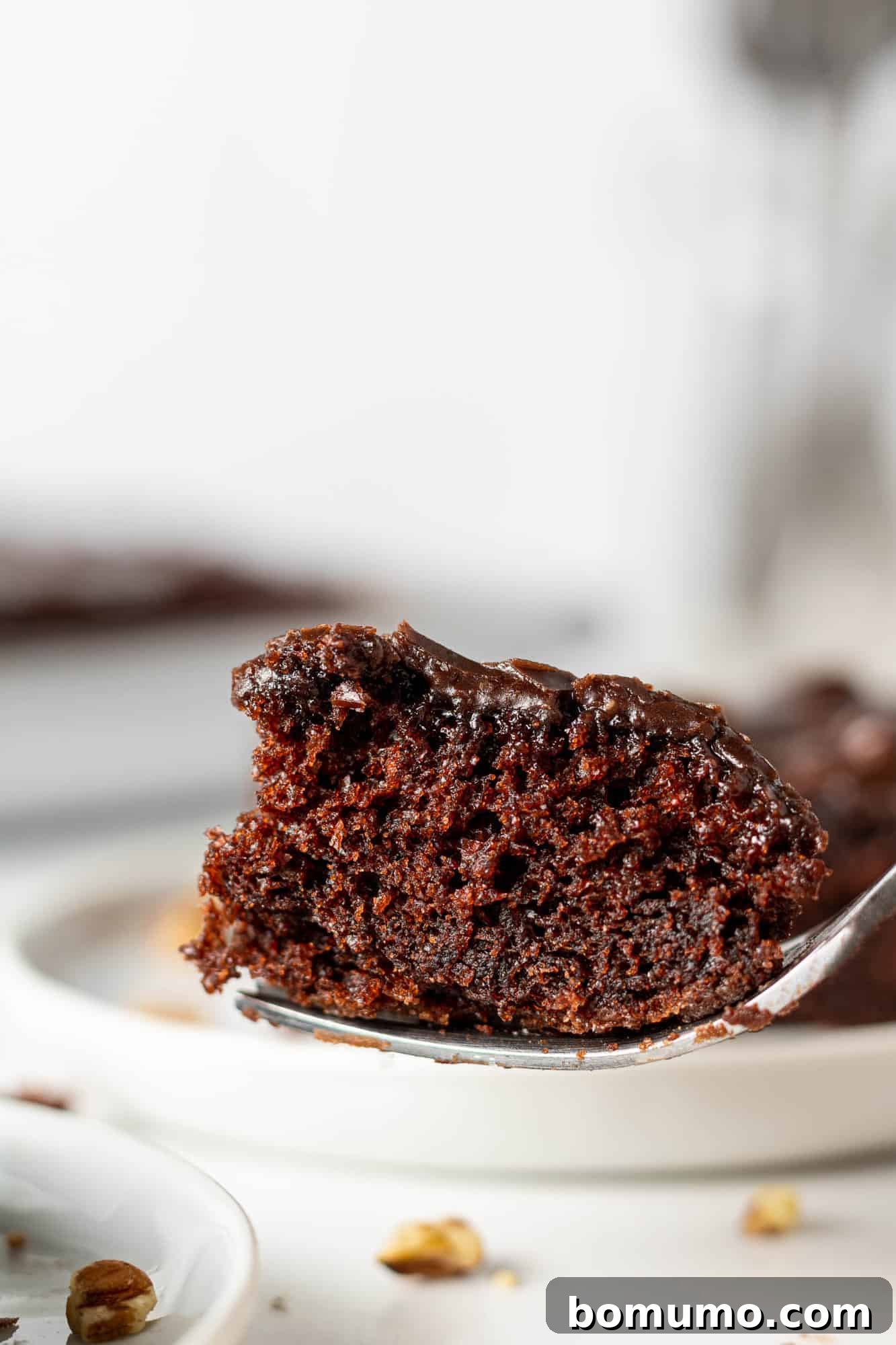 Texas-Sized Chocolate Delight 14 A fork piercing a piece of Texas Sheet Cake, showcasing its incredibly moist and tender crumb texture.