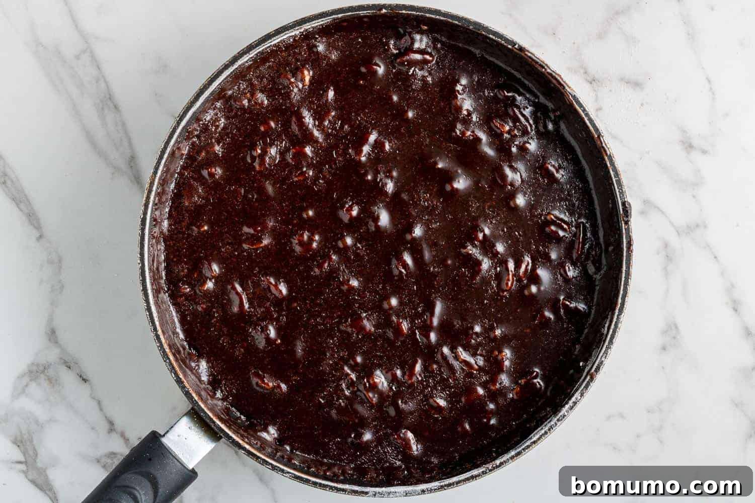 Texas-Sized Chocolate Delight 10 Rich chocolate frosting, studded with toasted pecans, simmering in a saucepan, ready to be poured over the hot cake.