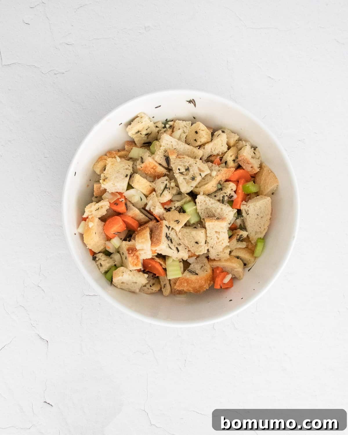 Stuffing in a white bowl before it is cooked.