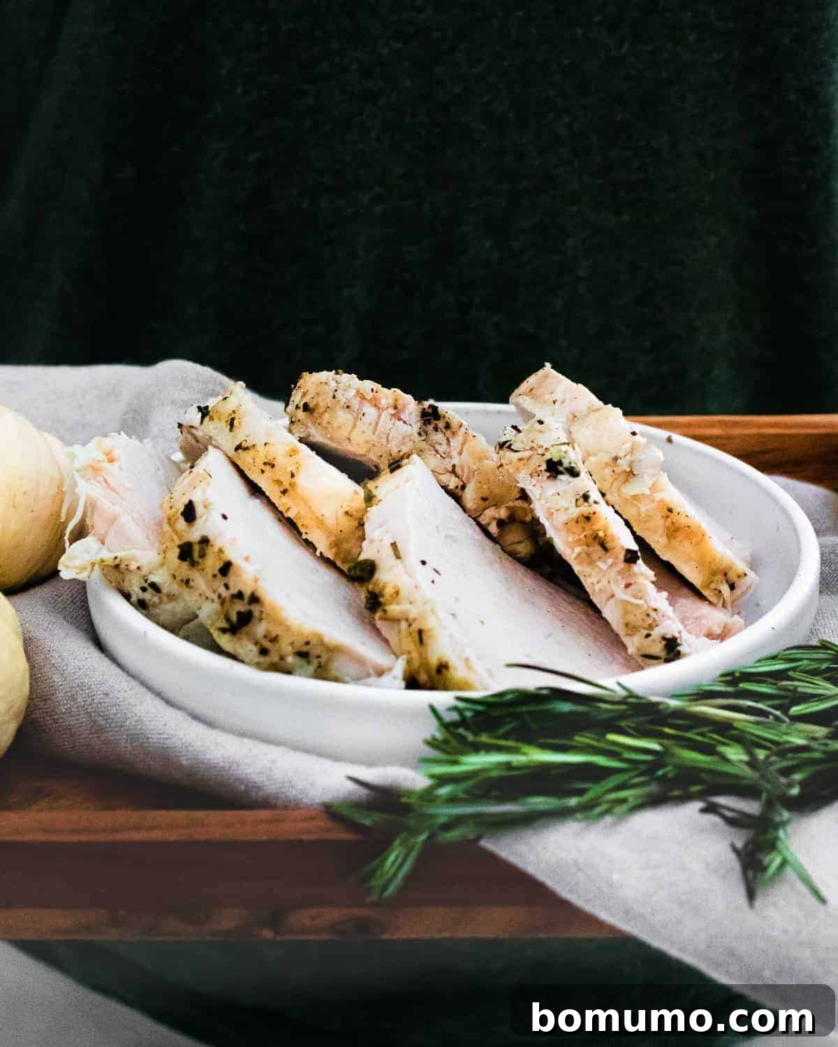 Slices of turkey on a platter, black background.