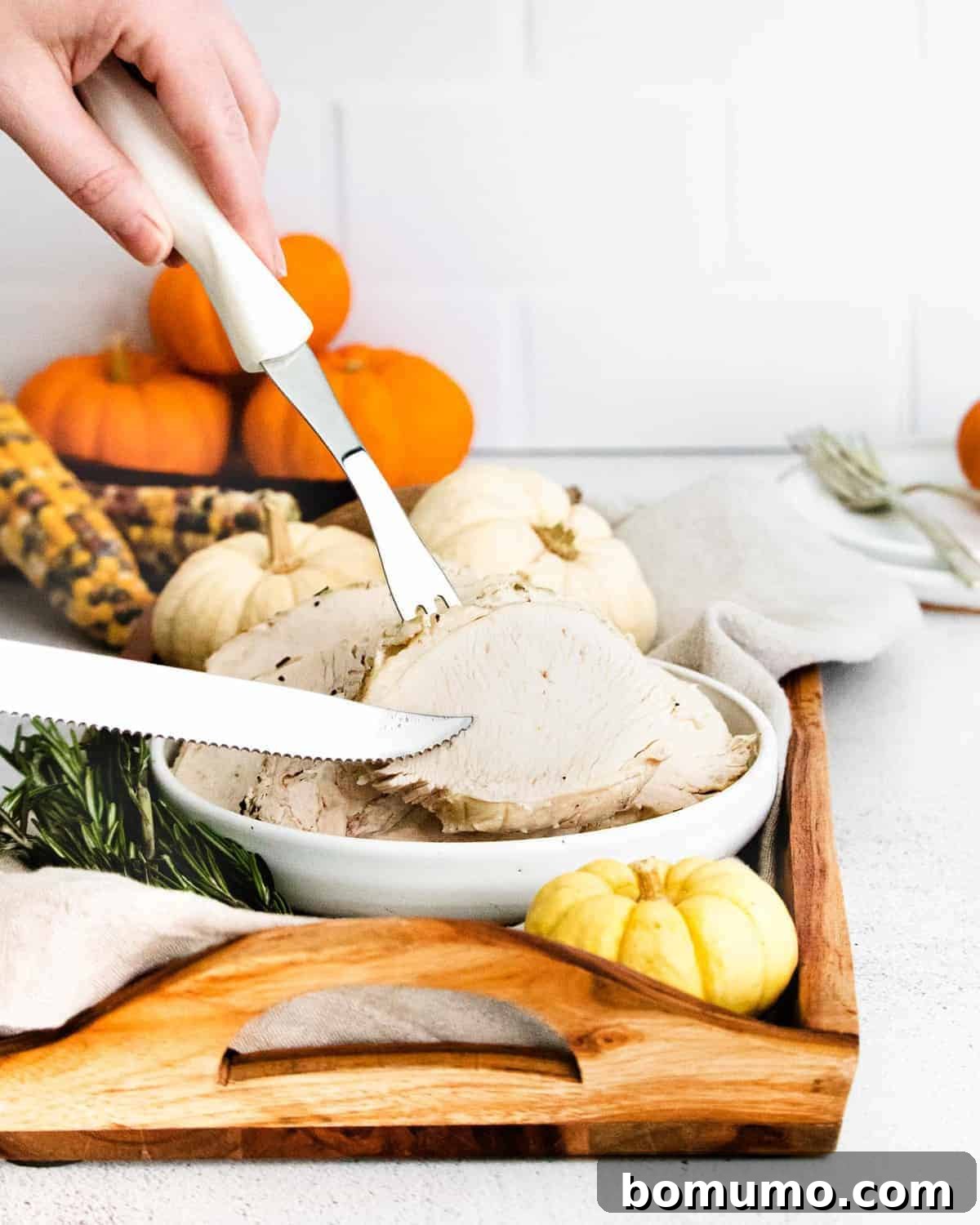 Turkey breast being sliced and served with silver knife and fork.